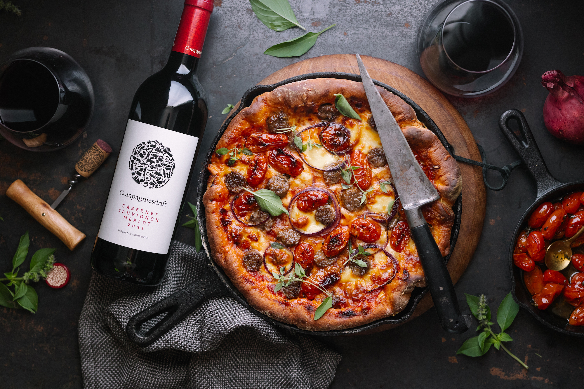 Deep dish pizza with boerewors, tomato & red onion